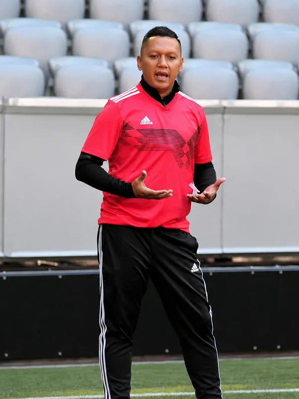 Head Coach Hyrizan Jufri instructing young footballers at a stadium