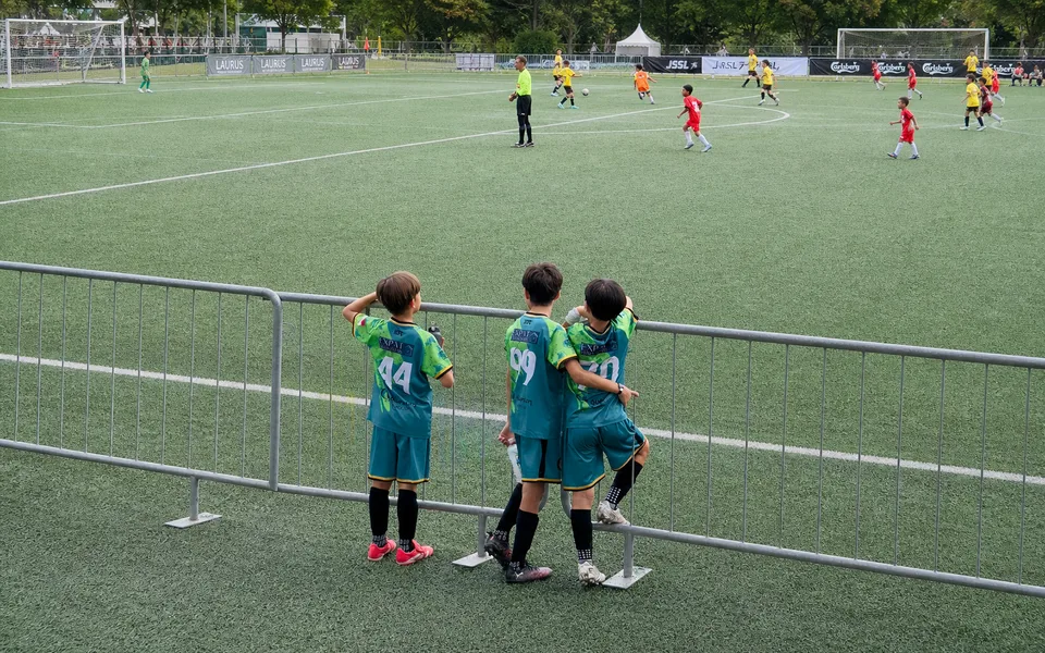 Young players supporting one another during football training